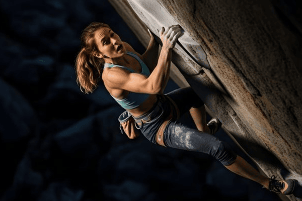 Sportive en train de faire de l'escalade. Image illustrant l'article sur la sophrologie dans la préparation sportive à Mons-en-Baroeul